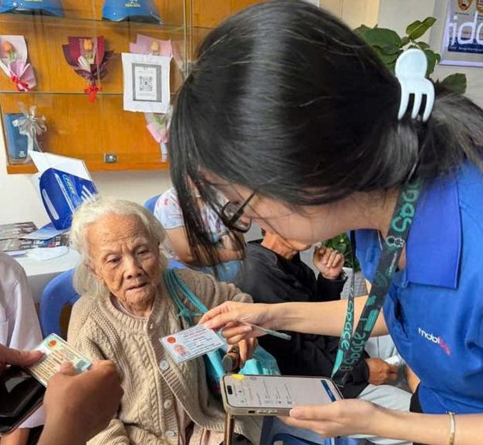 Nhân viên nhà mạng hỗ trợ người cao tuổi xác thực thông tin thuê bao trước ngày 15/6.