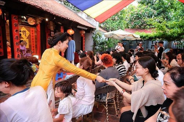 Nghệ nhân phát thẻ cho khản giả xem tại Bích Câu Đạo Quán. Ảnh: Phạm Tuấn Anh/TTXVN