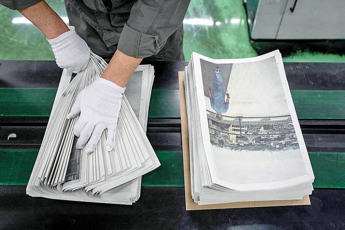 Một nhân viên đóng gói tác phẩm mang tên The Newspaper của nhiếp ảnh gia Kazuma Obara tại nhà máy in Kyoto Shimbun ở Kumiyama, tỉnh Kyoto, Nhật Bản. Ảnh: AFP