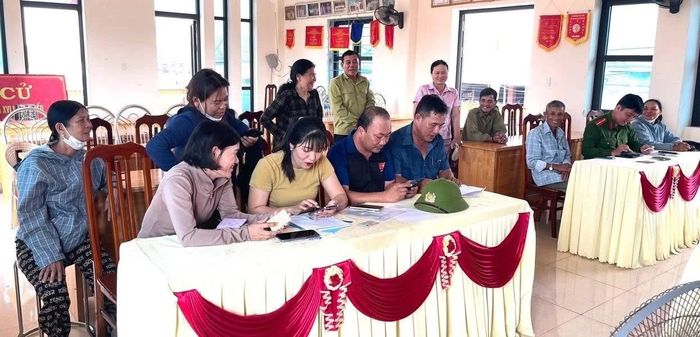 Tổ công nghệ số cộng đồng hướng dẫn cho người dân cài đặt các ứng dụng trên điện thoại - Ảnh: N.D
