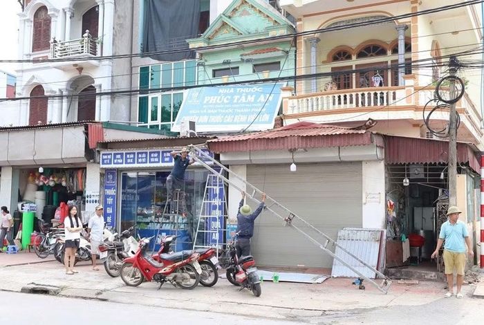 Người dân xã Hợp Tiến tháo dỡ mái tôn, biển quảng cáo vi phạm hành lang vỉa hè.