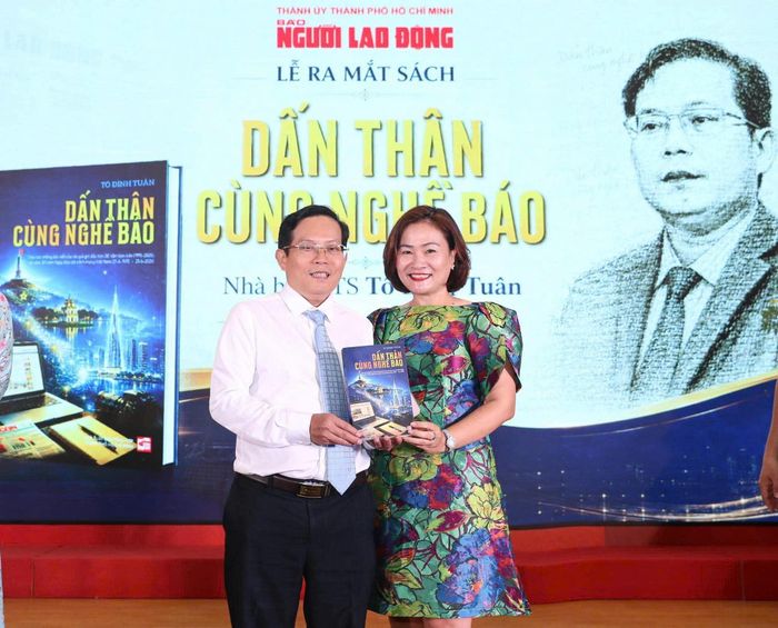 Bà Nguyễn Thị Thu Hà - Tổng biên tập Tạp chí Du lịch TTP.HCM hoa chúc mừng nhà báo - Tiến sĩ Tô Đình Tuân