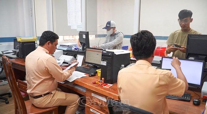 Cán bộ Phòng CSGT (Công an tỉnh Cà Mau) hướng dẫn người dân làm thủ tục đăng ký xe.