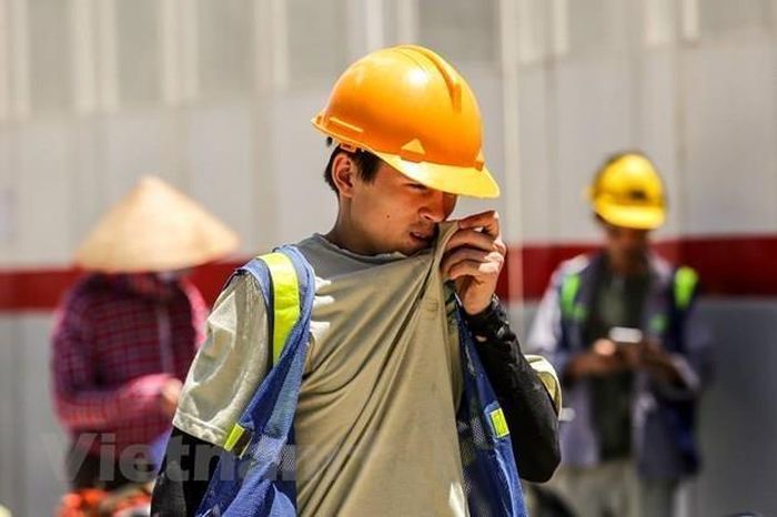Người lao động ngoài trời chịu nhiều ảnh hưởng khi nhiệt độ tại Hà Nội tăng cao. (Ảnh: suckhoedoisong.vn)