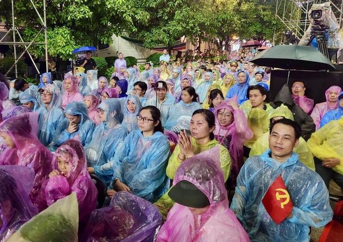 Dù cơn mưa lớn kéo dài trong suốt thời gian diễn ra chương trình, hàng nghìn người dân và đại biểu vẫn nán lại theo dõi đến phút cuối - Ảnh: VGP/Linh Chi