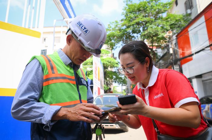 Với những khách hàng bận công việc, nhân viên Viettel đến tận nơi xác thực thông tin, bảo đảm quyền lợi cho khách hàng. Ảnh: Cẩm Thủy