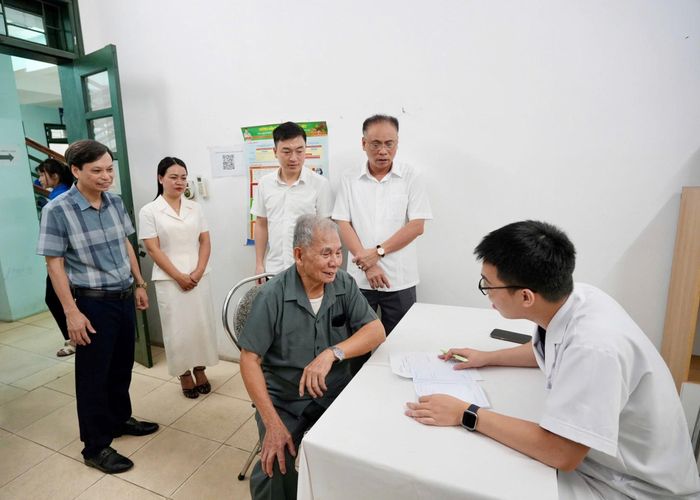 Lãnh đạo xã Đan Phượng trao đổi, động viên người có công tham gia khám sức khỏe. Ảnh: Ngân Nguyễn
