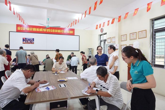 Tại các điểm lấy ý kiến, cán bộ cơ sở hướng dẫn người dân nghiên cứu tài liệu, nắm bắt thông tin, thể hiện ý kiến khách quan, trách nhiệm đối với phương án sắp xếp. Ảnh: Hoàng Anh