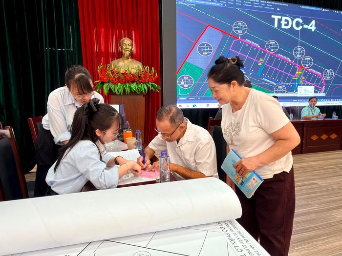 Người dân phấn khởi được bốc thăm đất tái định cư. Ảnh: Thanh Hà