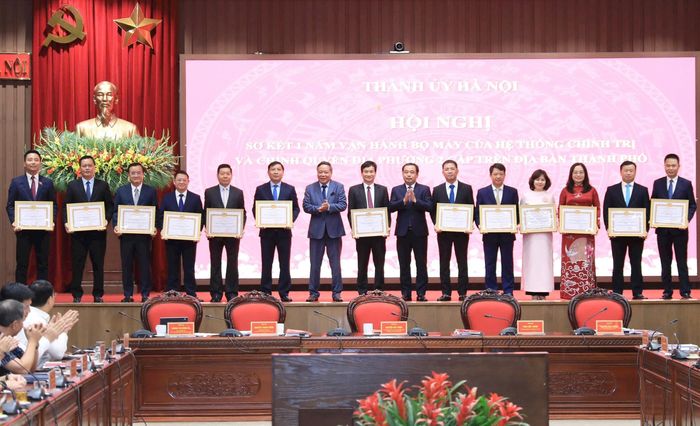 Các đồng chí lãnh đạo thành phố Hà Nội trao Bằng khen tặng các tập thể xuất sắc trong một năm triển khai vận hành bộ máy của hệ thống chính trị và chính quyền địa phương hai cấp, trong đó có xã Minh Châu. Ảnh: PV