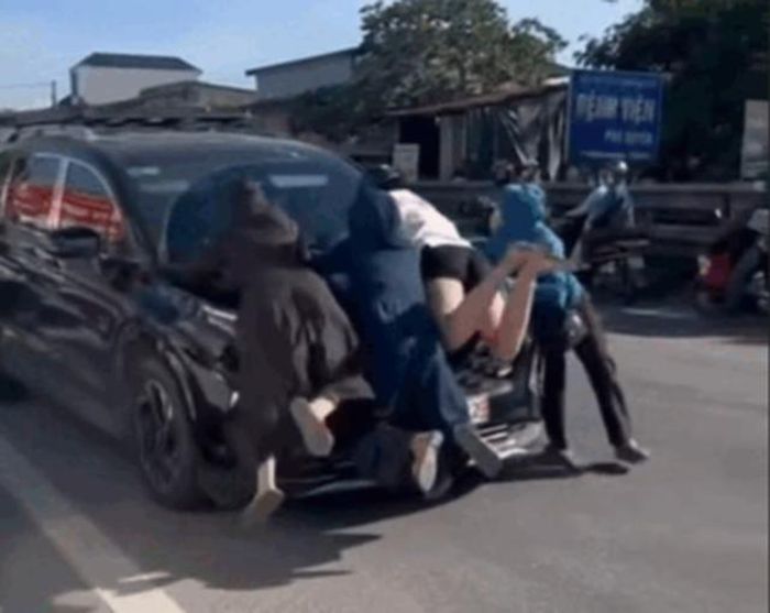 Ba người phụ nữ đu bám trên nắp capo xe ô tô con ở Phú Xuyên. Ảnh chụp màn hình