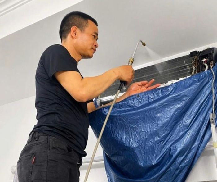 Anh Lê Bùi vệ sinh điều hòa cho khách. Ảnh: NVCC.