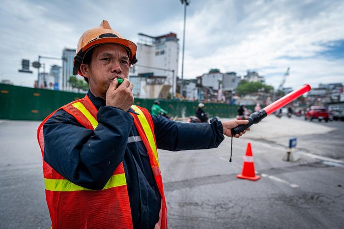  Trong những ngày đầu triển khai phương án tổ chức giao thông mới, nhà thầu bố trí lực lượng hướng dẫn giao thông để phân luồng, hạn chế ùn tắc tại khu vực thi công. 