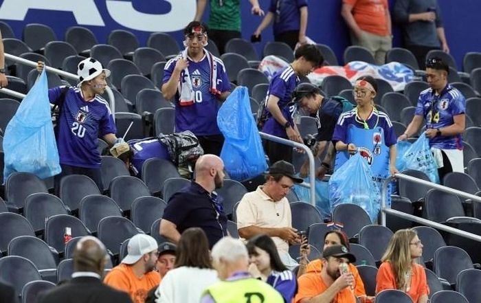 CĐV Nhật Bản dọn dẹp rác sau trận đấu ở sân Dallas, bang Texas, Mỹ. Ảnh: AFP