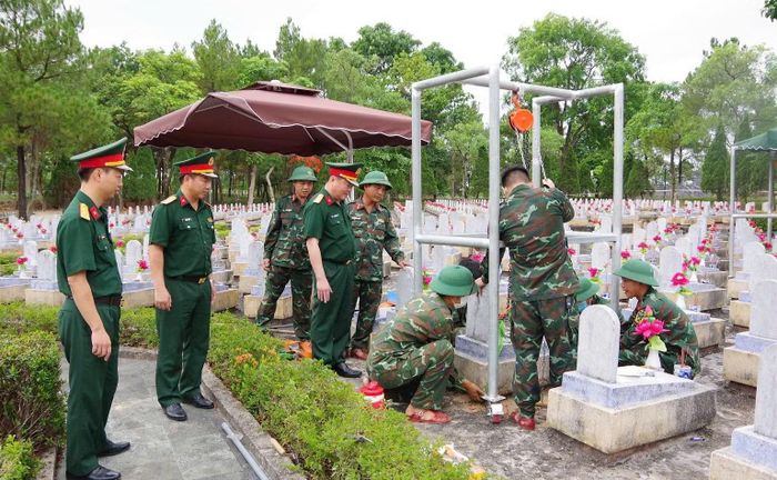 Đội 584 dùng ròng rọc tự chế để nâng phần bệ mộ liệt sĩ.