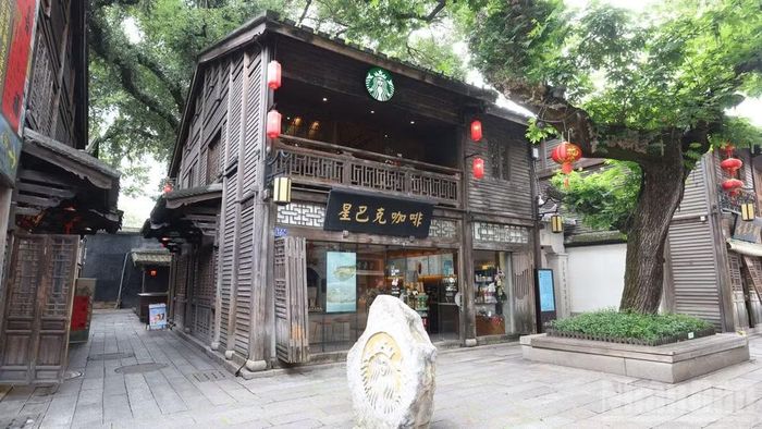Cửa hàng Starbucks mang phong cách hoài cổ hài hòa tuyệt đối với không gian di sản bao quanh. Việc khoác lên mình lối kiến trúc nhà lầu gỗ và đèn lồng truyền thống là minh chứng cho sự thành công của xu hướng bản địa hóa thương hiệu.