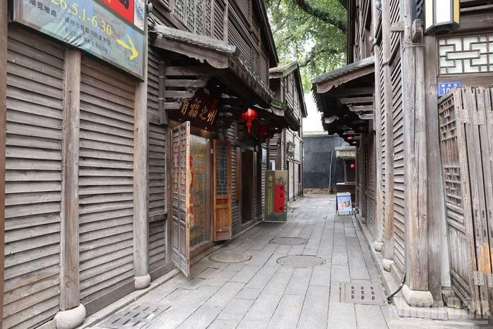 Một góc ngõ nhỏ lát đá thanh bình, tĩnh lặng tách biệt hẳn với sự sầm uất bên ngoài, tôn lên trọn vẹn kết cấu nhà cổ bằng gỗ Minh - Thanh được bảo tồn nguyên vẹn.