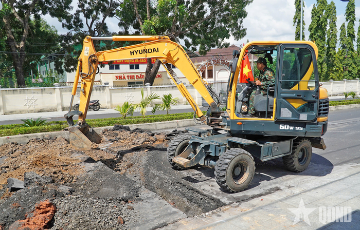 Lực lượng chức năng sử dụng cơ giới đào rãnh ngang vuông góc với đường Trường Chinh. 