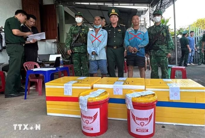 Hai cha con Nguyễn Lệnh và Nguyễn Hữu Nhân (dấu X) bị bắt cùng số thuốc nổ tang vật. Ảnh: TTXVN