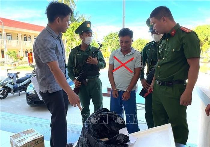 Đối tượng Ngô Thế Hải (dấu X) bị bắt cùng tang vật. Ảnh: TTXVN