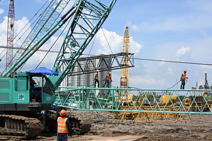  Công nhân và người lao động khẩn trương thi công trên công trường. Ảnh: VIỆT DŨNG 