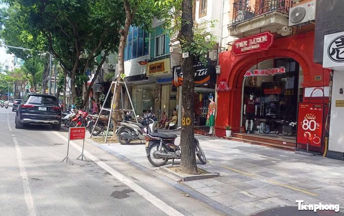 Một cửa hàng trên phố Nguyễn Hữu Huân đặt biển "nơi để xe cửa hàng" ngay dưới lòng đường.