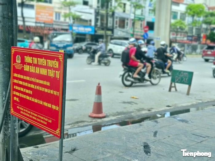Trên đường Hồ Tùng Mậu, mặc dù có biển cấm lấn chiếm lòng đường, vỉa hè nhưng cửa hàng vẫn đặt biển "cấm đỗ xe" và chóp nón cảnh báo giao thông dưới lòng đường.