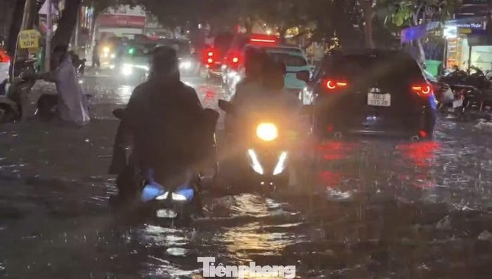Cách đó không xa, đường Xuân Thủy cũng rơi vào tình trạng tương tự. Nhiều xe bị chết máy, buộc chủ phương tiện phải dắt bộ giữa cơn mưa như trút nước. Ảnh: CTV