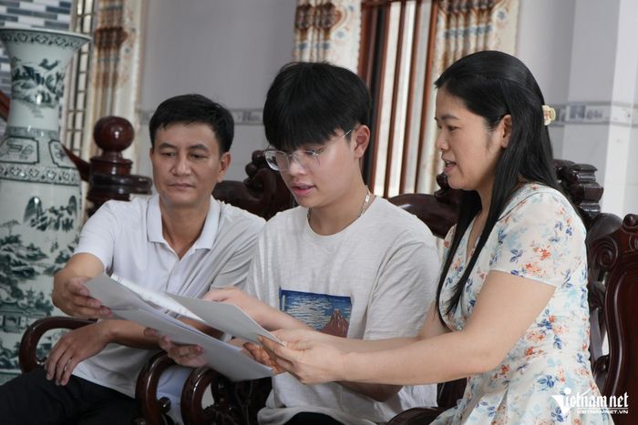 Vinh cùng bố mẹ xem lại thành tích em từng đạt. Ảnh: Hoàng Anh