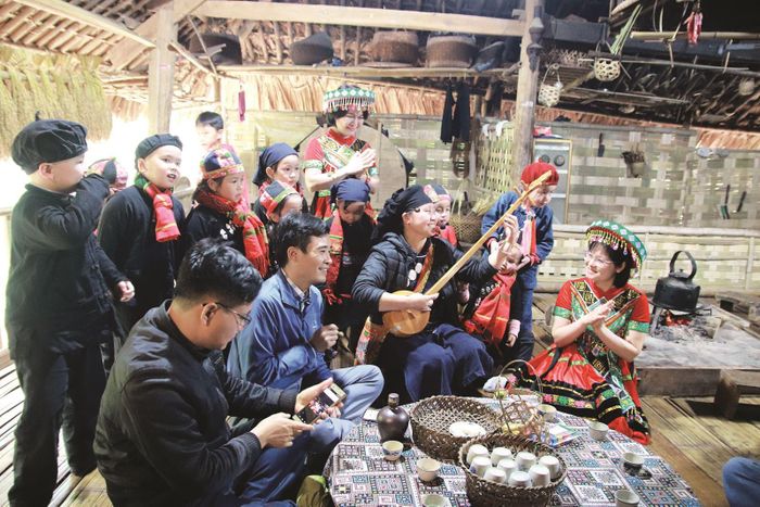 Du khách hào hứng cùng hòa vào điệu hát Then đàn Tính bên bếp lửa người Tày tại Khu bảo tồn làng nhà sàn dân tộc sinh thái Thái Hải, Thái Nguyên. Ảnh: Khu Bảo tồn làng nhà sàn dân tộc sinh thái Thái Hải