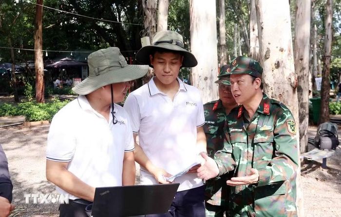 Đại tá Nguyễn Đình Chuẩn (ngoài cùng bên phải), Phó Chính ủy Bộ Tư lệnh Thành phố, Phó Trưởng Ban Chỉ đạo 515 trao đổi với PGS.TS Lê Văn Anh Cường (ngoài cùng bên trái), Đại học Khoa học Tự nhiên, Đại học Quốc gia Thành phố về phương pháp Radar xuyên lòng đất. (Ảnh: Xuân Khu/TTXVN)