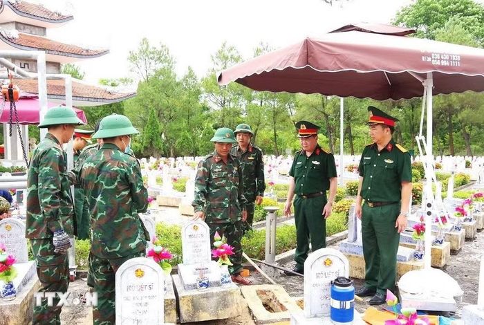 Các lực lượng đang thực hiện nhiệm vụ lấy mẫu, số hóa thông tin và bàn giao mẫu hài cốt liệt sĩ tại Nghĩa trang Liệt sỹ Quốc gia Đường 9. (Ảnh: TTXVN phát)
