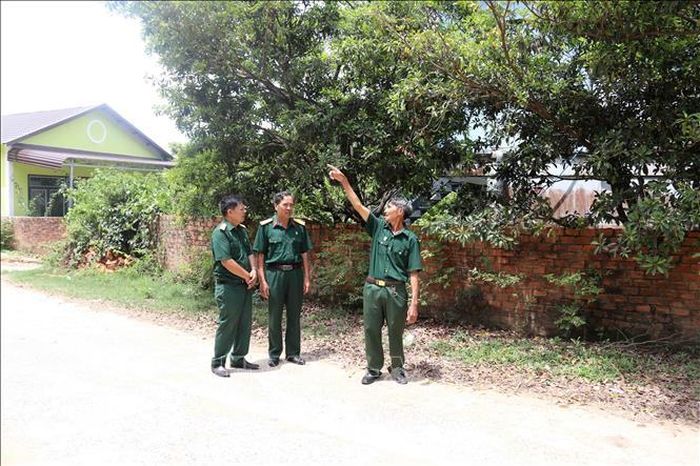 Cựu chiến binh Hán Vinh Hà (ngoài cùng bên phải) chia sẻ về con đường gia đình đã hiến đất và đóng góp kinh phí để xây dựng, kiên cố hóa.