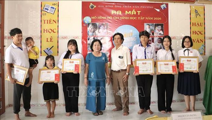 Ông Trần Văn Phương, chủ Hộ gia đình học tập trao khen thưởng cho các thành viên có thành tích xuất sắc trong học tập.