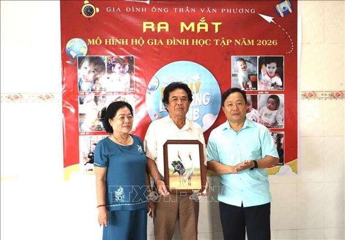 Ông Lê Thanh Long, Phó Chủ tịch UBND xã Tràm Chim trao quyết định và công nhận gia đình học tập cho hộ ông Trần Văn Phương.