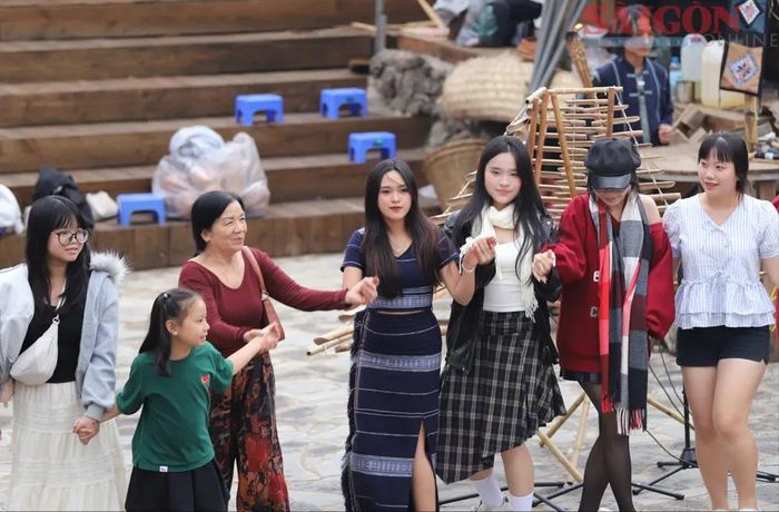 Nhóm du khách cùng cô gái K'Ho vui múa quanh đống lửa