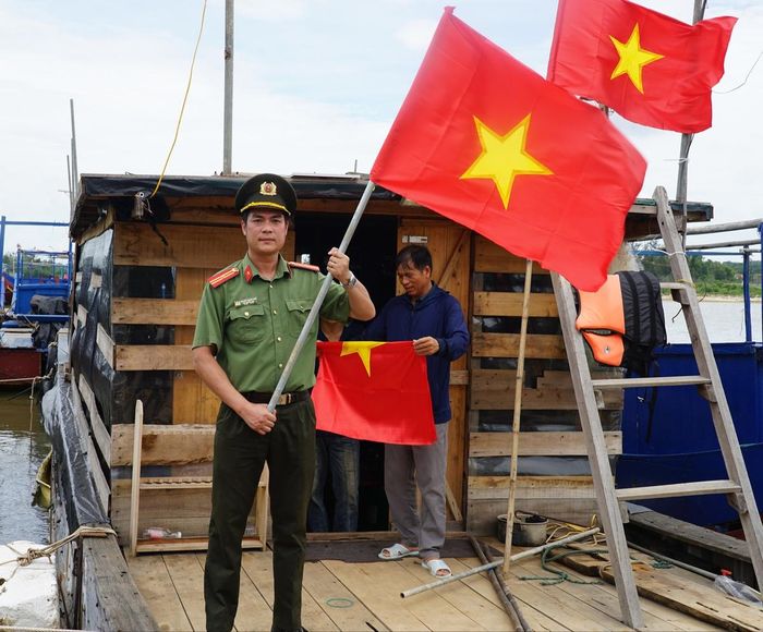 Thiếu tá Nguyễn Trường Sơn, Phó Trưởng Ban Thanh niên Công an tỉnh Quảng Ninh, tham gia đoàn trao cờ Tổ quốc cho ngư dân.