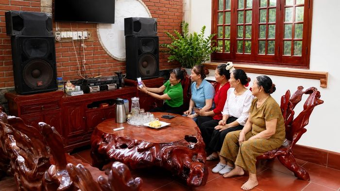 Hội viên vui vẻ xem lại video ghi lại những buổi tập luyện dân vũ.
