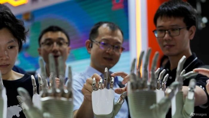 Khách tham quan trải nghiệm robot hình người tại một triển lãm AI ở Thượng Hải. Ảnh: AP