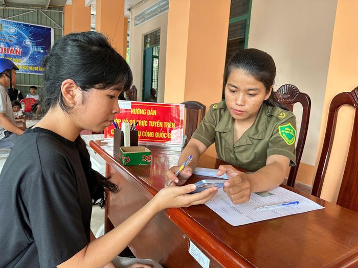 Chị Dương Thị Thu Mai hỗ trợ người dân đăng ký, thực hiện các thủ tục trên môi trường số. Ảnh: ÚT CHUYỀN