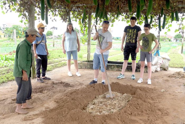 Du khách trải nghiệm làm nông tại làng rau Trà Quế. Ảnh: PHAN VINH