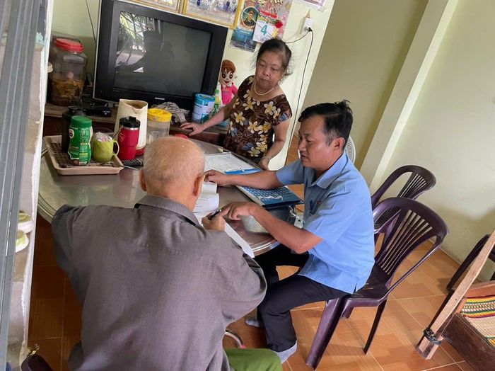 Cán bộ Trung tâm Phục vụ hành chính công xã Quế Phước đến tận nhà hướng dẫn người cao tuổi thực hiện thủ tục hành chính. Ảnh: ĐVCC