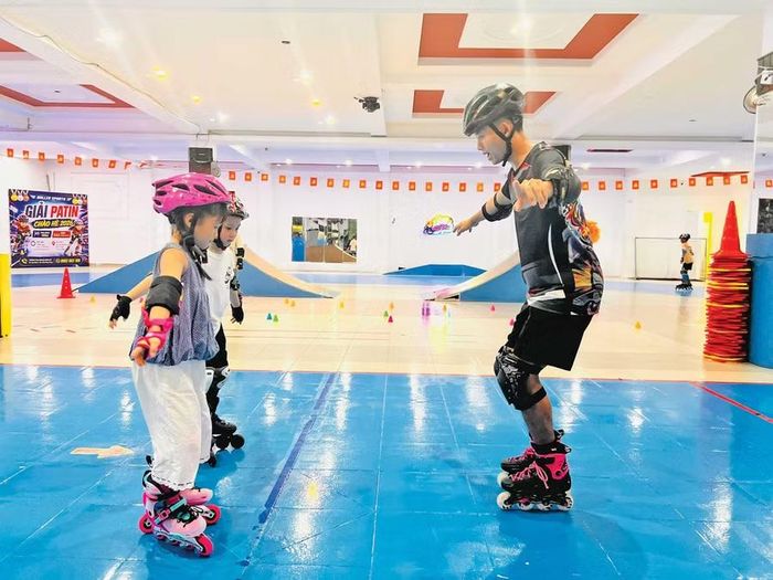 Huấn luyện viên của Câu lạc bộ patin Quy Nhơn hướng dẫn thiếu nhi kỹ năng giữ thăng bằng trên giày trượt. Ảnh: M.N