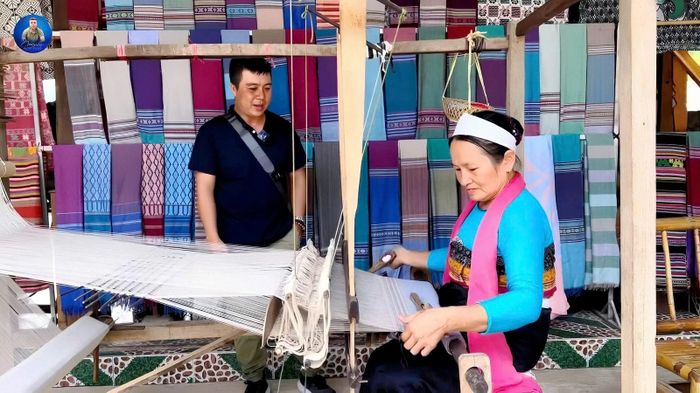 Khách du lịch tìm hiểu về nghề dệt thổ cẩm truyền thống của đồng bào dân tộc Mường.