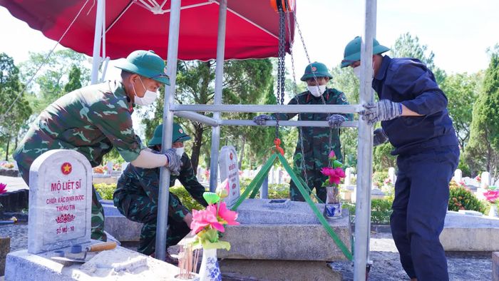 Để không thay đổi kết cấu các ngôi mộ, cán bộ, chiến sĩ Đội Tìm kiếm và Quy tập hài cốt liệt sĩ 584 đã tự chế ròng rọc nhằm giúp giảm sức người trong việc nâng, hạ mộ - Ảnh: Lê Trường