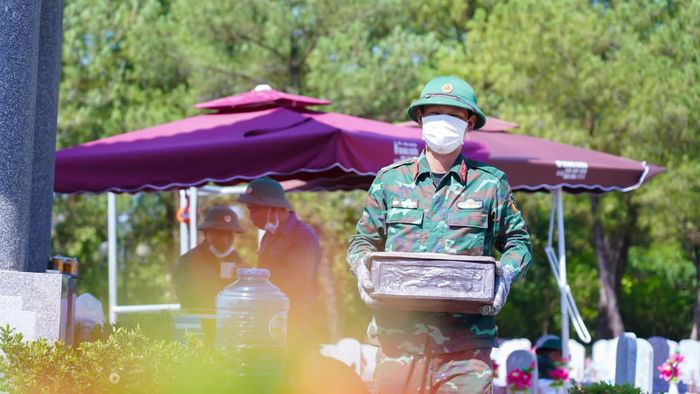 Sau khi cất bốc, hài cốt liệt sĩ được đưa đến khu vực lấy mẫu để giám định, sau đó gói buộc cẩn thận, cho vào tiểu và đưa về lại vị trí cũ, thực hiện công tác hoàn mộ - Ảnh: Lê Trường