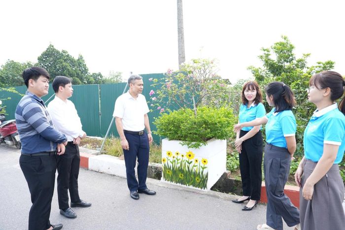 Các đại biểu tham quan công trình “Đoạn đường bích họa, nở hoa” tại thôn Hàn Lạc. Ảnh: Vân Thư