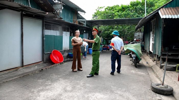 Lực lượng chức năng xã Hoài Đức tuyên truyền, nhắc nhở người dân không lấn chiếm vỉa hè, lòng đường. Ảnh: HĐ