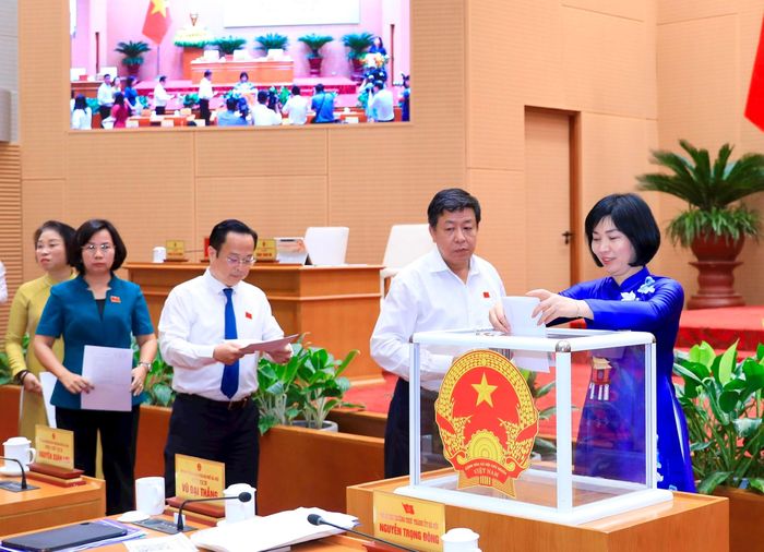 Các đại biểu tham gia bỏ phiếu thông qua nội dung nghị quyết tại kỳ họp. Ảnh: Thành Thái