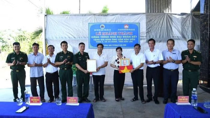 Đại diện các đơn vị và cấp ủy, chính quyền địa phương trao Cờ Tổ quốc, ảnh Bác Hồ và biểu trưng tặng "Nhà Đại đoàn kết" cho gia đình ông Viễn.